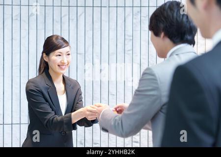 Un uomo d'affari si scambia i biglietti da visita alla reception Foto Stock