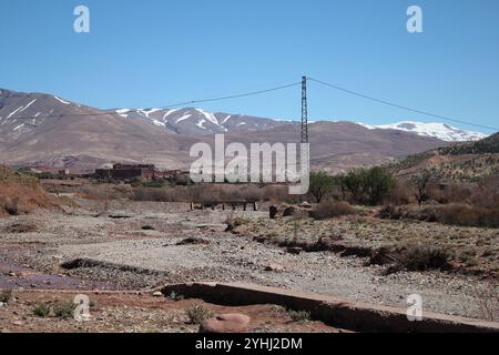 Strada ai margini del deserto del Sahara sotto le montagne dell'Atlante Foto Stock