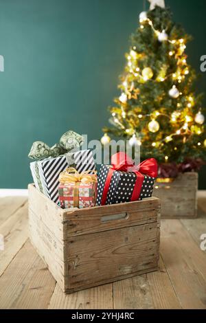 Tre scatole regalo e un albero di Natale in una scatola di legno Foto Stock