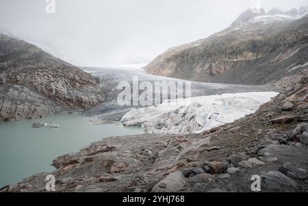 Ghiacciaio Rhône in una mattinata nebbiosa. Sempre più ghiacciaio in fusione nelle alpi svizzere, che si sta riducendo di dimensioni ogni giorno. Aspro paesaggio montano con pendii grigi. Foto Stock