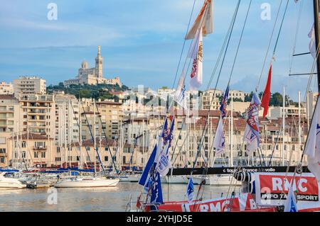 Marsiglia, Francia - 22 luglio 2010: Barche attraccate nel porto con il paesaggio urbano e la basilica di Notre-Dame de la Garde sullo sfondo. Foto Stock