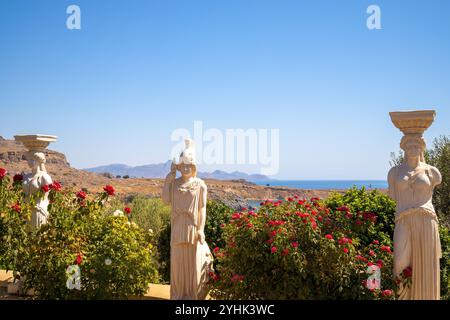 LINDOS, RODI - GRECIA - 6 LUGLIO 2022: Vista delle antiche statue con fiori in fiore sull'isola di Rodi. Foto Stock