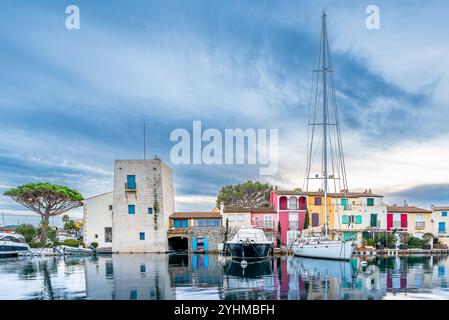 Vista panoramica del villaggio di Port Grimaud nel sud della Francia con il suo riflesso sul mare Mediterraneo contro il suggestivo cielo estivo Foto Stock