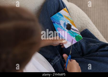 Creazione della bacheca di visione. Ragazza che taglia la foto in poltrona, vista dall'alto Foto Stock
