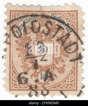 AUSTRIA — 1887: Francobollo marrone da 2 kreuzer che raffigura il valore sullo stemma della monarchia austriaca. L'aquila a doppia testa della Casa regnante degli Asburgo-Lorena fu usata dalle comuni istituzioni imperiali e reali (k. u. k.) dell'Austria-Ungheria o dalla doppia monarchia. L'aquila a doppia testa (o doppia aquila) è una carica associata al concetto di Impero. La maggior parte degli usi moderni del simbolo sono direttamente o indirettamente associati al suo uso da parte del tardo Impero bizantino, originariamente un emblema dinastico del Palaiologoi. Fu adottato durante il tardo Medioevo Foto Stock