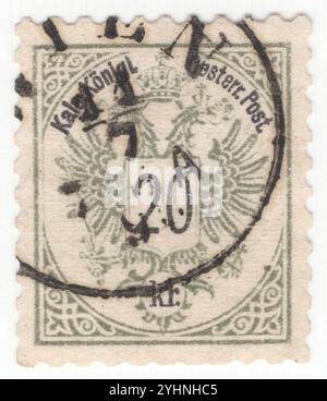 AUSTRIA — 1887: Francobollo grigio da 20 kreuzer che raffigura il valore sullo stemma della monarchia austriaca. L'aquila a doppia testa della Casa regnante degli Asburgo-Lorena fu usata dalle comuni istituzioni imperiali e reali (k. u. k.) dell'Austria-Ungheria o dalla doppia monarchia. L'aquila a doppia testa (o doppia aquila) è una carica associata al concetto di Impero. La maggior parte degli usi moderni del simbolo sono direttamente o indirettamente associati al suo uso da parte del tardo Impero bizantino, originariamente un emblema dinastico del Palaiologoi. Fu adottato durante il tardo Medioevo Foto Stock