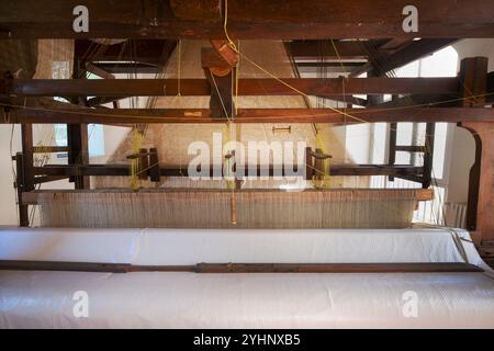 Antico telaio in legno per la tessitura della seta che crea tessuti preziosi nella storica fabbrica di seta del sito reale di San Leucio, in Campania Foto Stock