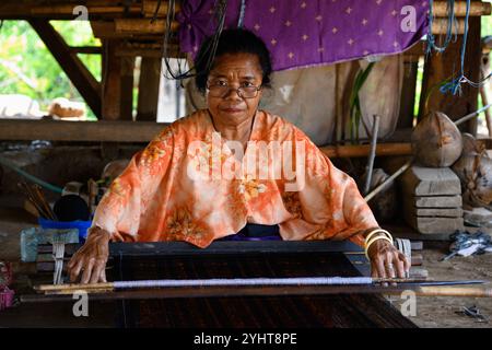 Nggela, Flores, Indonesia - ottobre 28 2024: Donna tessitura tradizionale Ikat Sarong nel villaggio tradizionale di Lio. Foto Stock