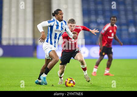 John Smith's Stadium, Huddersfield, Inghilterra, Regno Unito il 12 novembre 2024. Nigel Lonwijk (23), difensore dell'Huddersfield Town, in battaglia con il centrocampista del Manchester United U21 Ethan Ennis (49) durante la partita di stadio tra Huddersfield Town FC e Manchester United FC U21 Bristol Street Motors EFL Trophy Northern Group F al John Smith's Stadium, Huddersfield, Inghilterra, Regno Unito il 12 novembre 2024 Credit: Every Second Media/Alamy Live News Foto Stock