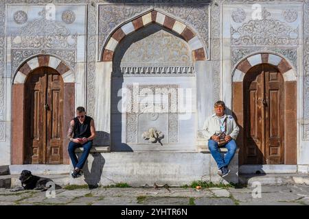 24/10/2024. Istanbul, Turchia. I turisti riposano sulla Fontana del Sultano Ahmed III nella grande piazza di fronte alla porta Imperiale del Palazzo Topkapı a Istanbul, Turchia. Fu costruita sotto il sultano ottomano Ahmed III nel 1728, nello stile del periodo Tulip. Era un centro sociale e luogo di ritrovo durante il periodo ottomano di Costantinopoli. Foto: © Simon Grosset Foto Stock