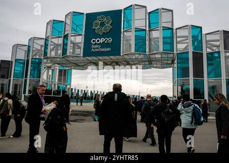 Baku, Azerbaigian. 12 novembre 2024. I partecipanti camminano accanto all'ingresso della COP29, sede della conferenza ONU sui cambiamenti climatici, un evento organizzato dall'UNFCCC allo stadio olimpico di Baku. La COP29, in vigore dal novembre 11-22, si concentra sulla procedura di compensazione delle emissioni di carbonio e sul fondo per perdite e danni. Credito: SOPA Images Limited/Alamy Live News Foto Stock