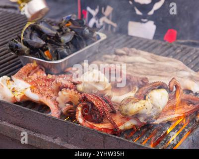 Polpo fresco e calamari alla griglia in una bancarella del mercato. Catania, Sicilia, Italia Foto Stock