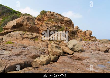 Scogliera rocciosa erosa con vegetazione sparsa Foto Stock