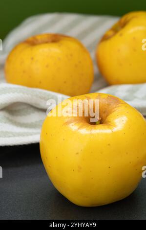 Immagine verticale di tre mele di Opal gialle pronte da mangiare. Foto Stock