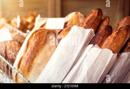 Pane - assortimento di prodotti artigianali appena sfornati, tra cui baguette e panini. Il pane è un alimento fondamentale della dieta di molte culture. Foto Stock