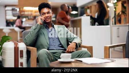Business, hotel e uomo in sala con telefonata, caffè e bagagli nella hall per comunicare con il tuo viaggio. Viaggi, prenotazioni e uomini d'affari alla reception su Foto Stock