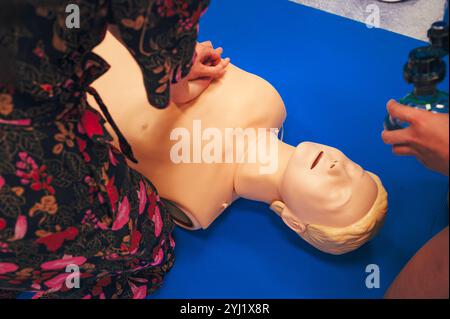 Studenti di medicina che praticano le compressioni toraciche RCP su una figura umana sdraiata a terra durante una sessione di addestramento salvavita Foto Stock