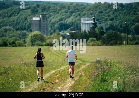 Coppia di trail running sul prato estivo Foto Stock