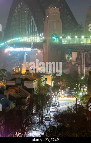 Una nebbia leggera si deposita sul Sydney Harbour Bridge in Australia nelle prime ore del mattino, visto da Observatory Hill at the Rocks con Lower Fort Street in primo piano. Foto Stock