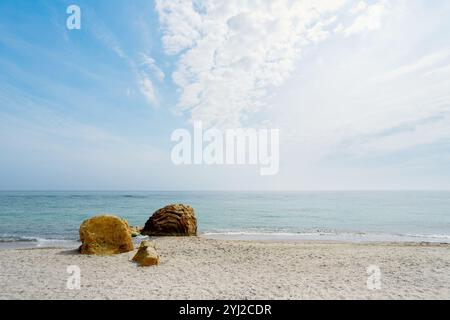 Grandi pietre sulla riva del Mar Nero. Rocce di pietra gialla su una spiaggia estiva di sabbia. Vista mare e cielo blu con soffici nuvole. Odesa, Ucraina. Foto Stock