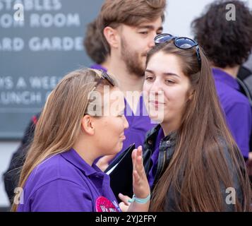 A fine estate a Framlingham Suffolk, il National Youth Choir of Great Britain, con polo viola abbinate, esegue un concerto all'aperto sul mercato Foto Stock