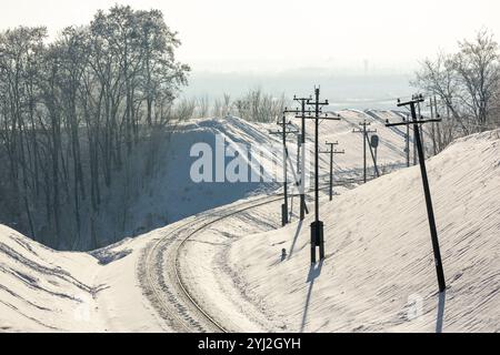 Ferrovia innevata in inverno. Binari ferroviari innevati. Ferrovia vuota in inverno. Foto Stock