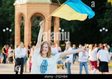 Romny, regione di Sumy, Ucraina. Giornata della gioventù, 29 giugno 2014. Una ragazza in un costume nazionale ucraino in un abito ricamato tiene una bandiera Ucraina. Protesta Foto Stock