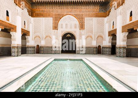 Cortile interno della Madrasa Ben Youssef con intricati mosaici e piscina, architettura tradizionale islamica, Marrakech, Marocco Foto Stock