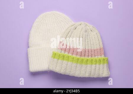 Cappelli di lana caldi su sfondo lilla, vista dall'alto Foto Stock