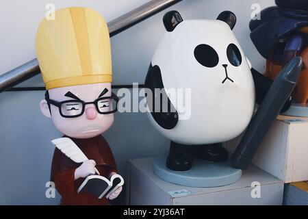 Una stravagante raccolta di personaggi dei cartoni animati, tra cui un panda e uno studioso, adorna un vivace angolo di strada a Hong Kong. Foto Stock