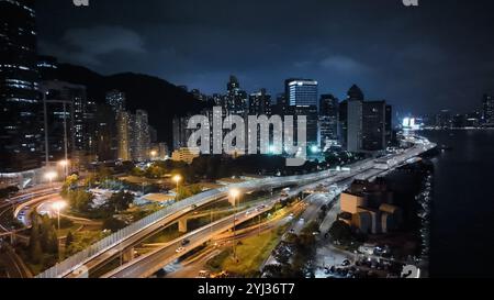 Una vista mozzafiato di Hong Kong di notte che mostra grattacieli illuminati e strade animate sotto un cielo scuro. Foto Stock
