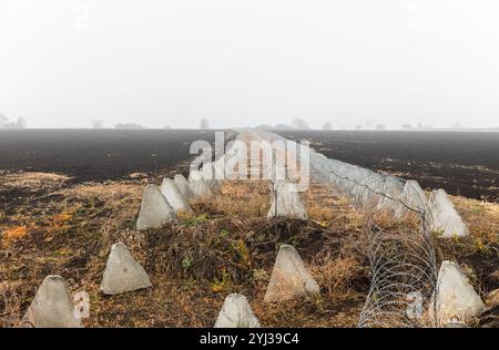 Regione di Kharkiv, Ucraina. 8 novembre 2024. Fortificazioni dei denti del drago e filo spinato nella regione di Charkiv durante la guerra russo-Ucraina. Nella regione di Charkiv, le fortificazioni difensive svolgono un ruolo cruciale nel garantire la sicurezza in mezzo alle tensioni in corso. Le barriere in calcestruzzo e le linee di filo spinato contribuiscono a impedire l'accesso non autorizzato e aggiungono livelli di protezione. Queste strutture sono collocate strategicamente in campi aperti per scoraggiare potenziali minacce. (Foto di Mykhaylo Palinchak/SOPA Images/Sipa USA) credito: SIPA USA/Alamy Live News Foto Stock