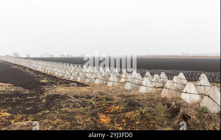 Regione di Kharkiv, Ucraina. 8 novembre 2024. Fortificazioni dei denti del drago e filo spinato nella regione di Charkiv durante la guerra russo-Ucraina. Nella regione di Charkiv, le fortificazioni difensive svolgono un ruolo cruciale nel garantire la sicurezza in mezzo alle tensioni in corso. Le barriere in calcestruzzo e le linee di filo spinato contribuiscono a impedire l'accesso non autorizzato e aggiungono livelli di protezione. Queste strutture sono collocate strategicamente in campi aperti per scoraggiare potenziali minacce. (Credit Image: © Mykhaylo Palinchak/SOPA Images via ZUMA Press Wire) SOLO PER USO EDITORIALE! Non per USO commerciale! Foto Stock