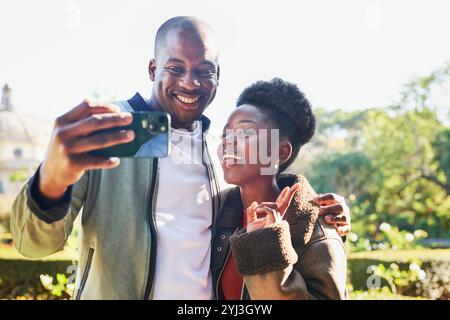 Coppia gioiosa che porta un Selfie insieme in un bellissimo parco cittadino Foto Stock