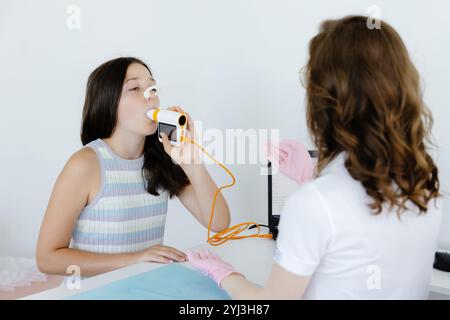 Ragazza che verifica la funzione respiratoria tramite spirometria nell'ufficio medico. Diagnosi della funzione respiratoria nella malattia polmonare. Foto Stock