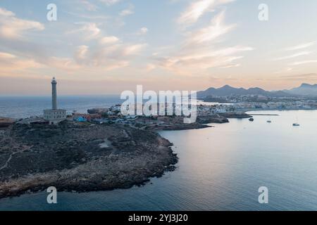 Vista aerea del faro e villaggio di Cabo de Palos, Cartagena, regione di Murcia, Spagna, al tramonto sul Mar Mediterraneo Foto Stock