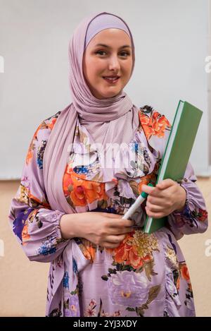 Ritratto di un'insegnante musulmana sorridente in classe. Foto Stock