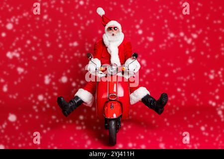 Foto a lunghezza intera di un giro pazzo della barba bianca del nonno in pensione retro scooter vento soffiare faccia sorpresa evitare incidenti usura x-mas costume cappotto da sole Foto Stock
