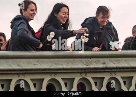 Londra, Regno Unito. 21 settembre 2017. Diverse centinaia di manifestanti camminano dal Borough Market al Ponte di Westminster portando fiori bianchi in una London for Peace Walk in concomitanza con Barcellona, Parigi e altre città del mondo in occasione della giornata Mondiale della Pace. Sul ponte di Westminster alcuni gettarono fiori e petali nel fiume Tamigi. La marcia fu organizzata dalla Women's March London. I manifestanti indossavano il nero e camminavano in silenzio per piangere la recente perdita di vite preziose a causa di violenze in tutte le forme, inclusi terroristi, statali, aziendali, domestici. Hanno dichiarato che non ci può essere pace senza giustizia, Foto Stock