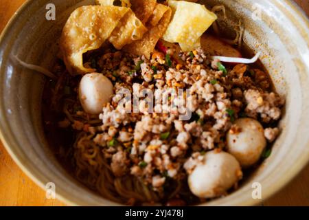 Tradizionale cibo di strada tailandese locale Tom Yum Moo SAB zuppa di spaghetti o spaghetti in brodo caldo e acido con maiale macinato, polpette di maiale, germogli di soia e. Foto Stock