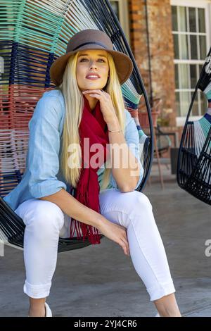 La bellezza bionda trasuda gioia con l'elegante abbigliamento autunnale, che irradia gli spiriti in una splendida giornata autunnale Foto Stock