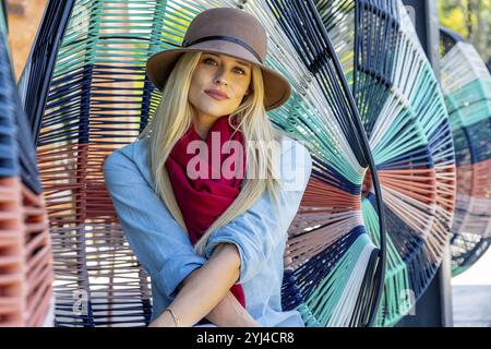 La bellezza bionda trasuda gioia con l'elegante abbigliamento autunnale, che irradia gli spiriti in una splendida giornata autunnale Foto Stock