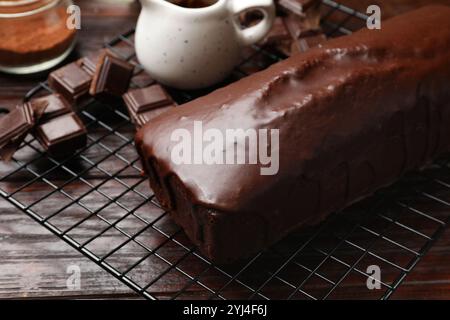 Gustosa torta di spugne e pezzi di cioccolato su un tavolo di legno, primo piano Foto Stock