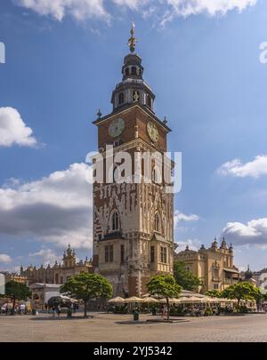 La maestosa Torre del Municipio di Cracovia si erge orgogliosamente, bagnata dalla luce del sole contro soffici nuvole, in Polonia Foto Stock