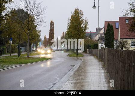 Langweid, Baviera, Germania - 13 novembre 2024: Immagine simbolica dei cambiamenti climatici e delle nevicate in Baviera. Precipitazioni su una strada in un villaggio *** Symbolbild Wetterumschwung und Schneefall a Bayern. Niederschlag auf einer Straße in einem Dorf Foto Stock
