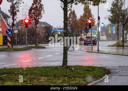 Langweid, Baviera, Germania - 13 novembre 2024: Immagine simbolica dei cambiamenti climatici e delle nevicate in Baviera. Precipitazioni su una strada in un villaggio *** Symbolbild Wetterumschwung und Schneefall a Bayern. Niederschlag auf einer Straße in einem Dorf Foto Stock