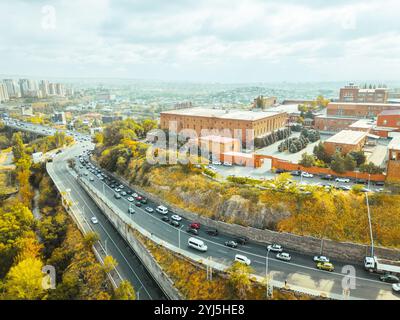 Erevan, Armenia - 20 ottobre 2024: Veduta aerea dall'alto degli edifici della fabbrica di Yerevan Ararat Brandy. Museo Ararat. Veicoli nel traffico sull'autostrada M5 Foto Stock
