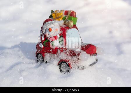 Allegro pupazzo di neve giocattolo su un'auto porta regali. Giocattolo di Natale Foto Stock