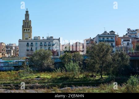 La torre dell'orologio di Moncada e la chiesa di Reixach si innalza su un cielo azzurro, mostrando i suoi intricati dettagli architettonici e il fascino storico. Foto Stock