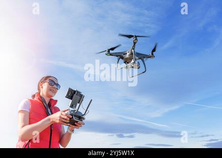 Una giovane donna controlla un drone. Foto Stock